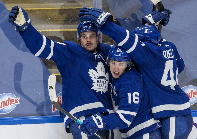 Toronto Maple Leafs center Auston Matthews (34) is congratulated by teammates Mitchell Marner (16) and Morgan Rielly (44) after scoring the game winning goal against the Winnipeg Jets during overtime in an NHL hockey game, Thursday, March 11, 2021 in Toronto. (Frank Gunn/The Canadian Press via AP)