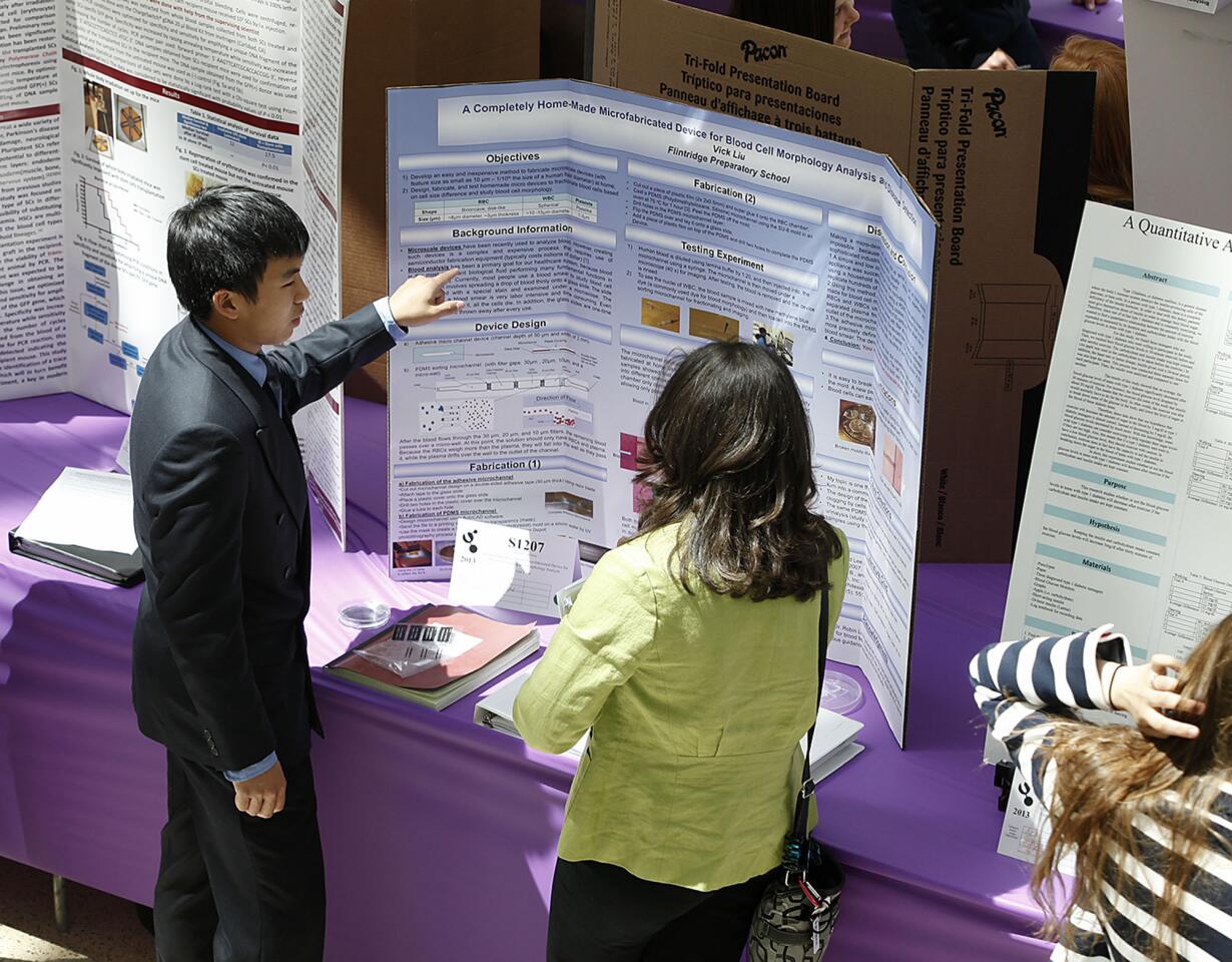 Flintridge Prep's Vick Liu, 15 and a freshman, talks about his project with Dr. Margie Dell during exhibition at the 62nd California State Science Fair competition at the California Science Center in Los Angeles on Tuesday, April 16, 2013.