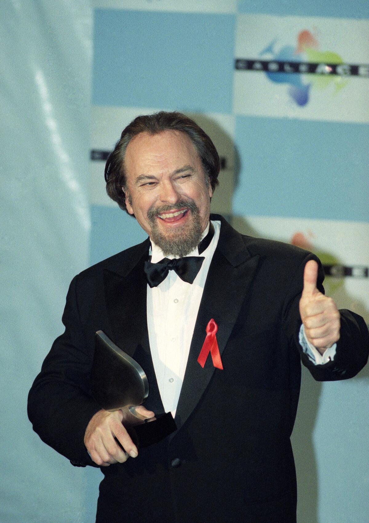 Rip Torn gives a thumbs-up to photographers after winning the Emmy for Actor in a Comedy Series for HBO's "The Larry Sanders Show" in 1995.