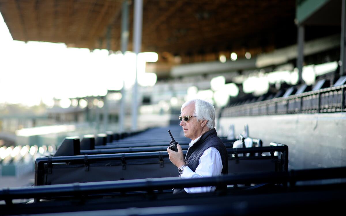 Hall of Fame horse trainer Bob Baffert keeps an eye on his horses during early morning workouts at Santa Anita racetrack.