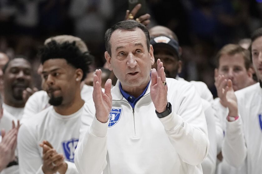 Duke coach Mike Krzyzewski applauds while being recognized prior to the team's game against North Carolina on Saturday.