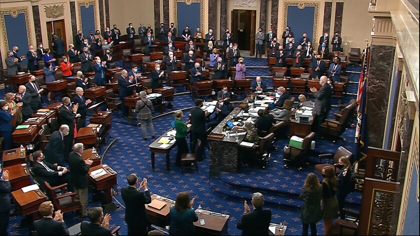 In this image from video, senators stand and applaud support staff, before the final vote on the Senate version of the COVID-19 relief bill in the Senate at the U.S. Capitol in Washington, Saturday, March 6, 2021. (Senate Television via AP)
