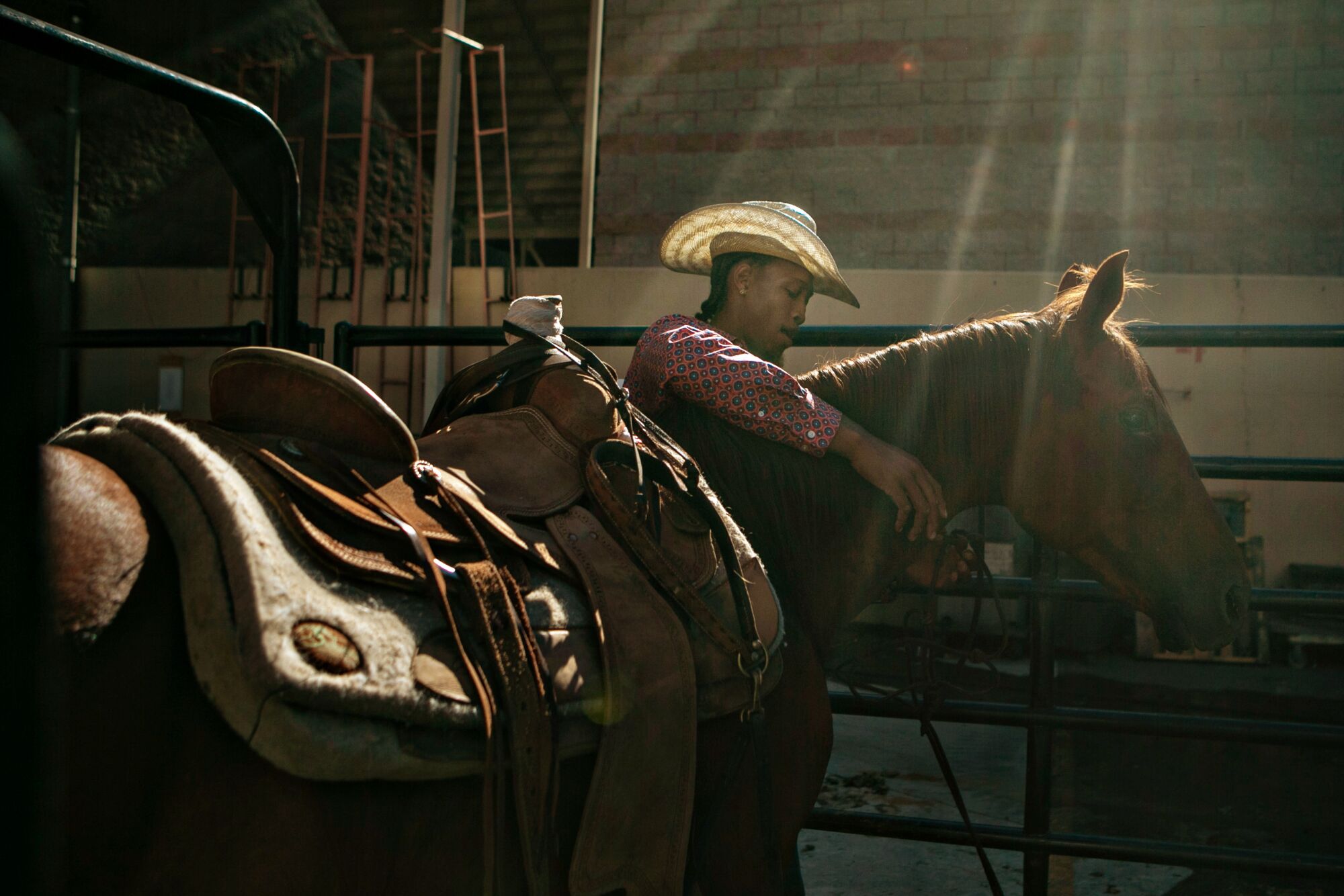 A cowboy with his arms around a horse's neck