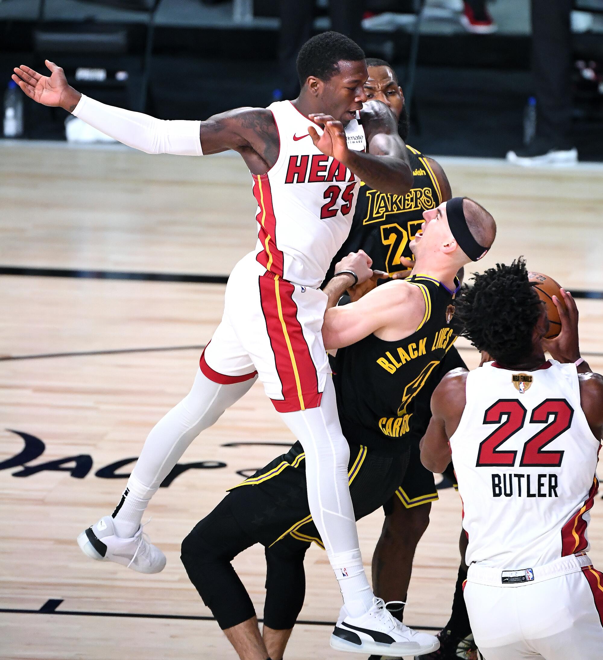 Miami's Kendrick Nunn charges into Lakers guard Alex Caruso during the second quarter of Game 2 on Friday.