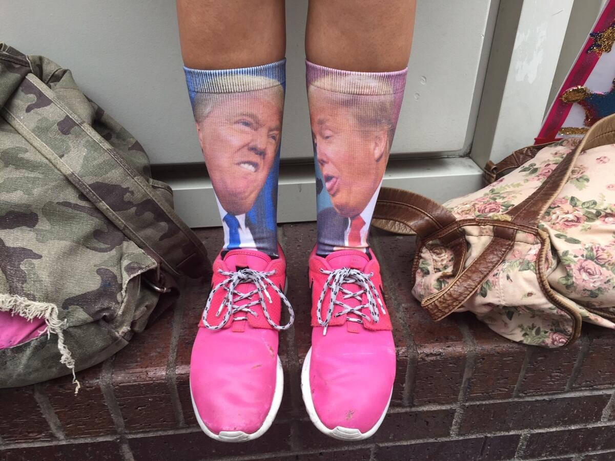 President Trump supporter Bianca Turano, 23, of La Puente, wearing appropriate socks, waits across the street from the InterContinental Los Angeles Downtown Hotel where Trump will spend the night.
