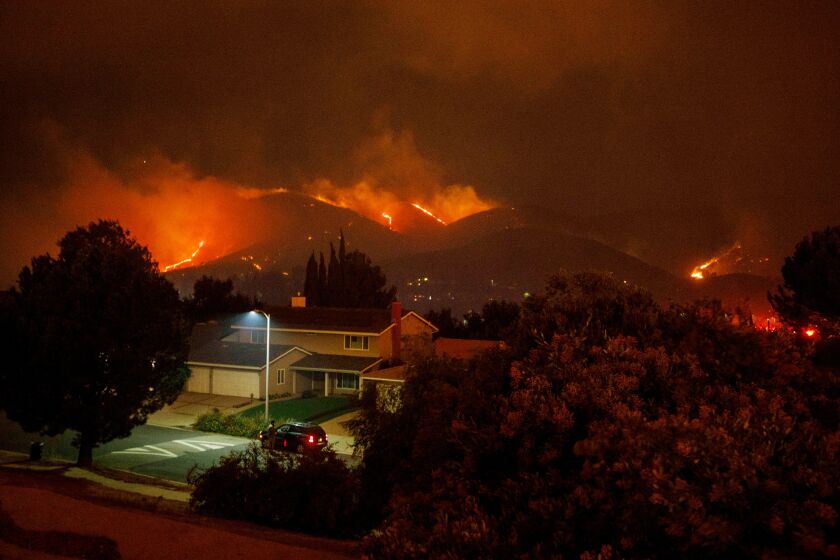 The Saddleridge fire burns behind homes on Friday, October 11, 2019 in the Porter Ranch neighborhood of Los Angeles, CA. (Patrick T. Fallon/ For The Los Angeles Times)