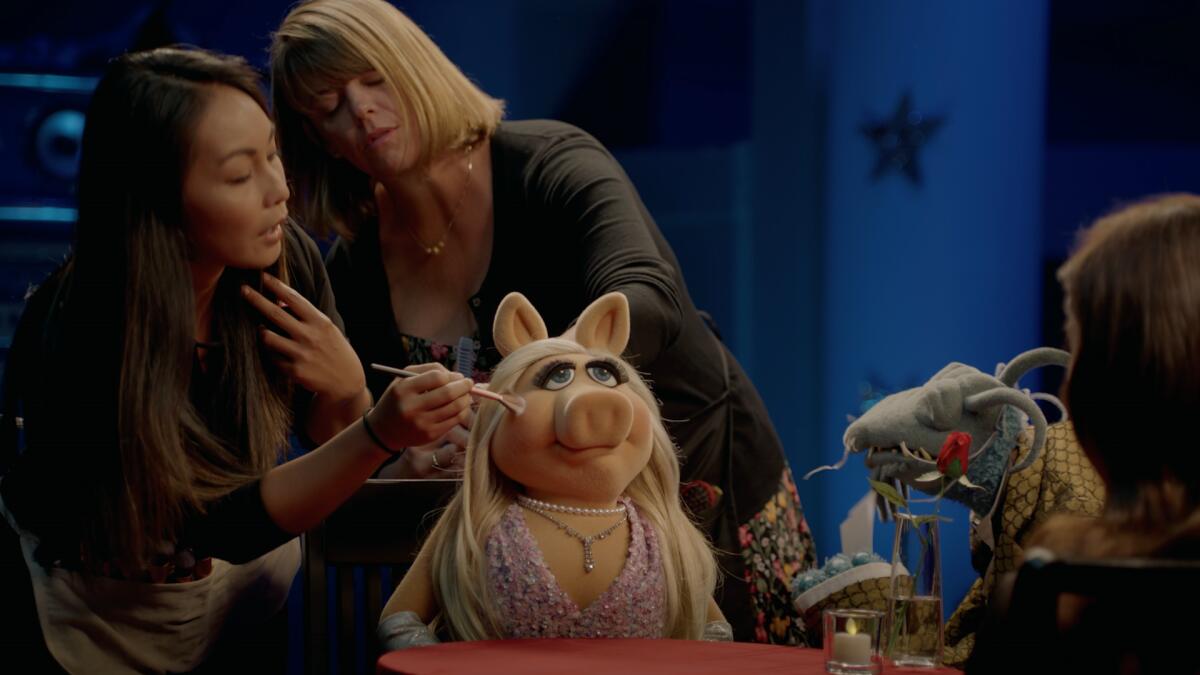 Miss Piggy gets a touchup during an interview with Aubrey Plaza on the Disney+ series "Muppets Now."