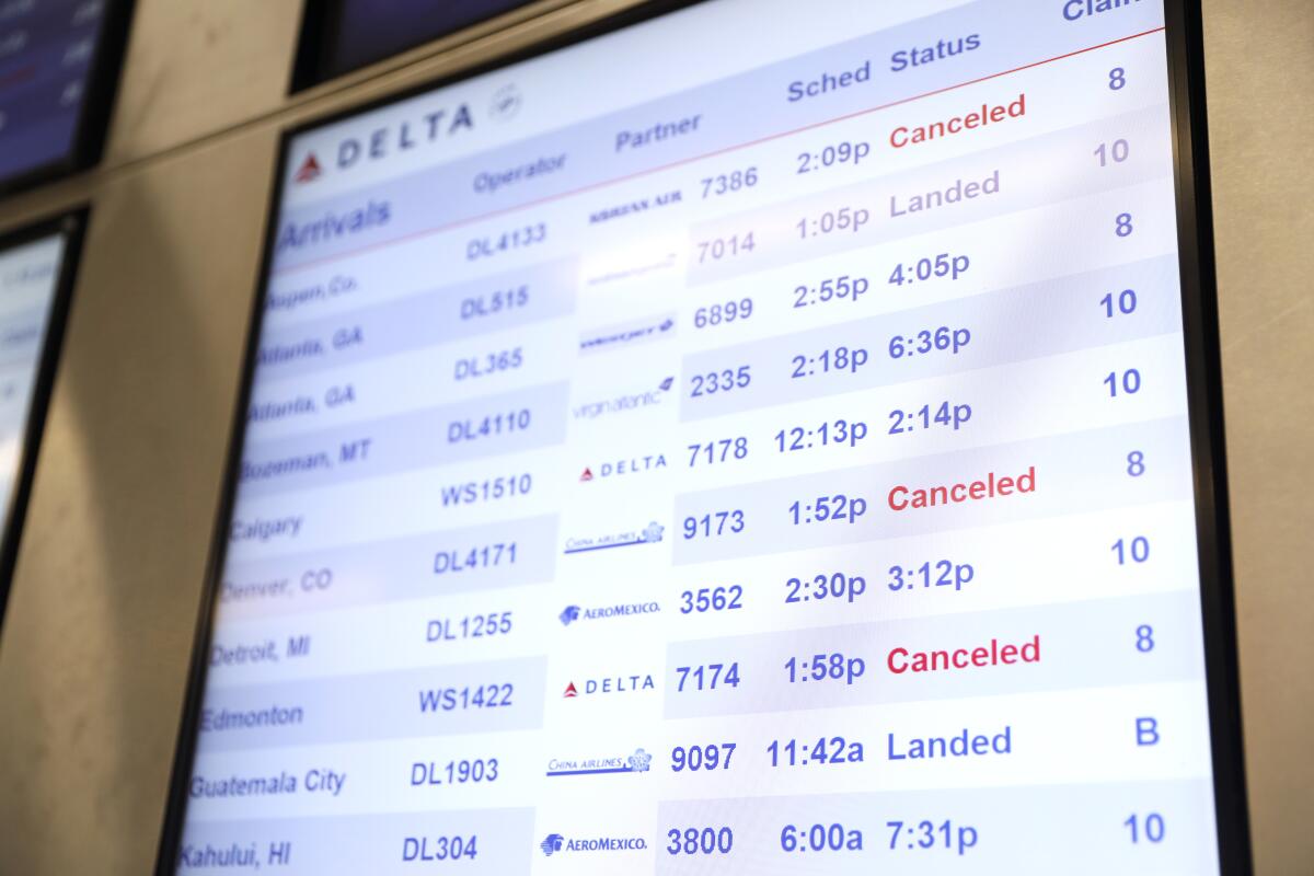 A few canceled flights show up on the departure board in the Delta terminal at LAX on Dec. 27.