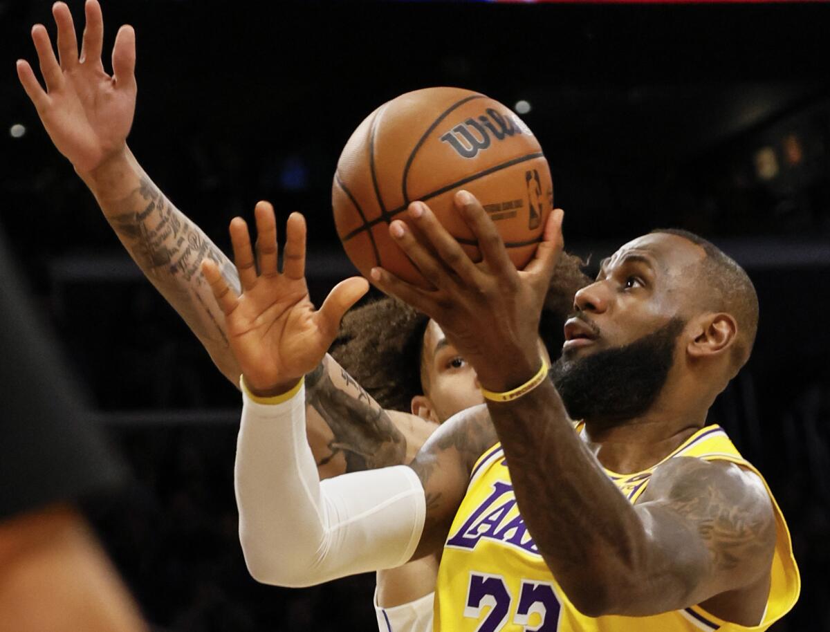 Lakers forward LeBron James attempts to shoot over Mavericks center Dereck Lively II 
