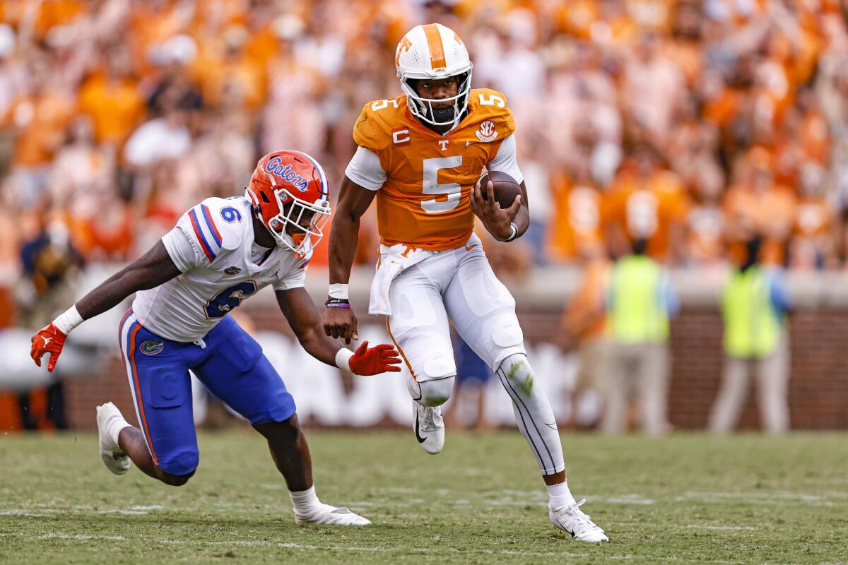 Tennessee quarterback Hendon Hooker (5) escapes from Florida linebacker Shemar James (6) during the second half of an NCAA college football game Saturday, Sept. 24, 2022, in Knoxville, Tenn. Tennessee won 38-33. (AP Photo/Wade Payne)