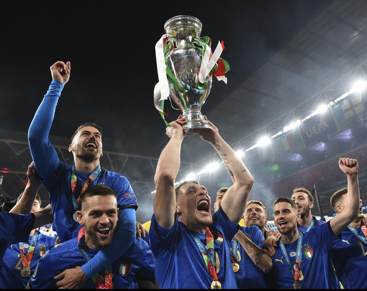 Italy's Andrea Belotti holds up the trophy.