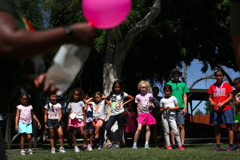 LONG BEACH, CA. -- MONDAY, JULY 3, 2017 -- Girl Scouts watch an experiment during a summer day camp in Long Beach. Girl Scout troops of girls ages 5 to 17 are being taught everything from robotics to video game design these daysâ and now the organization is adding cybersecurity to its list of badges and patches. ( Rick Loomis / Los Angeles Times )
