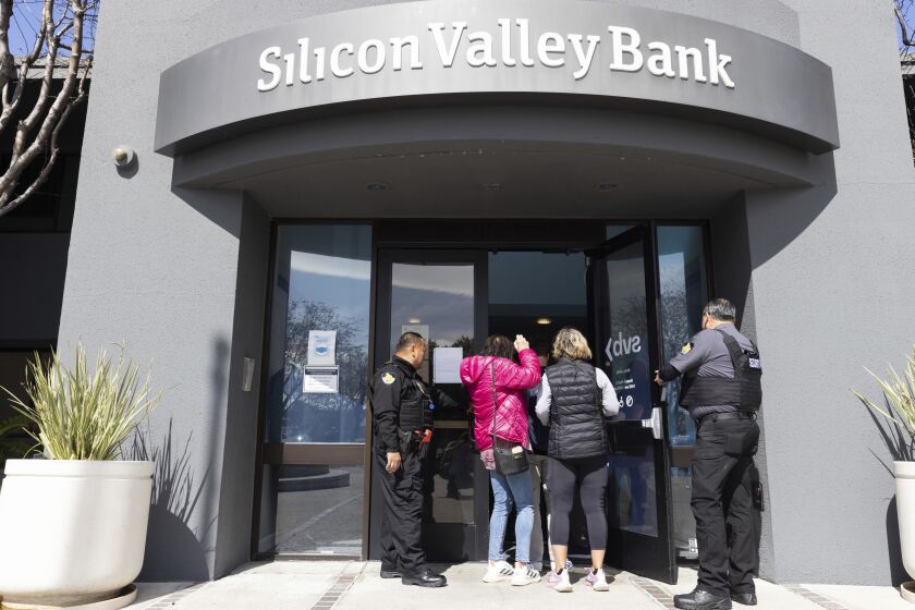 Security guards let individuals enter the Silicon Valley Bank's headquarters in Santa Clara, Calif., on Monday, March 13, 2023. The federal government intervened Sunday to secure funds for depositors to withdraw from Silicon Valley Bank after the banks collapse. Dozens of individuals waited in line outside the bank to withdraw funds. (AP Photo/ Benjamin Fanjoy)
