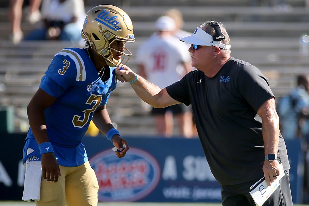 UCLA koçu Chip Kelly dördüncü çeyrekte oyun kurucu Dante Moore ile konuşuyor.