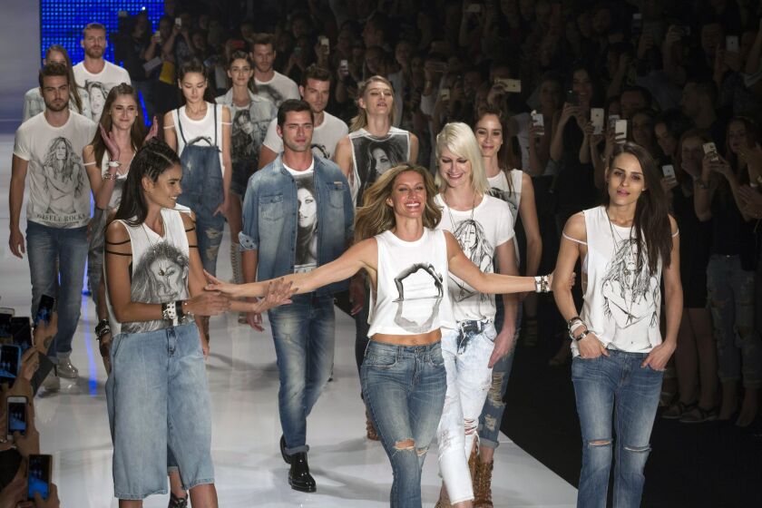 Brazilian model Gisele Bundchen (center front) is surrounded by other models as she walks her last runway, at the Colcci show.
