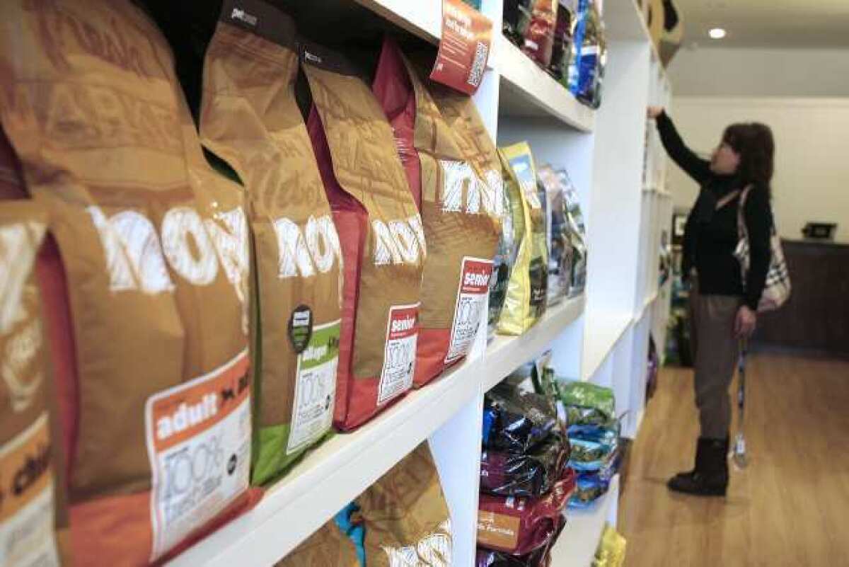 Owner Christina Lee of Button Nose Natural Pet Food Shop adjusts items on a shelf in her new store on Foothill Boulevard in La Cañada Flintridge.