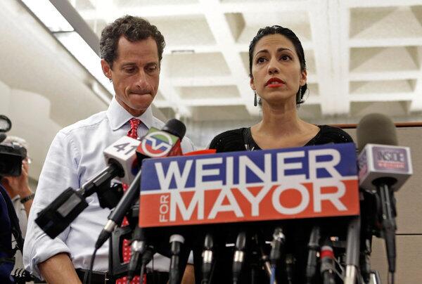 New York mayoral candidate Anthony Weiner, left, listens as his wife, Huma Abedin, speaks during a news conference at the Gay Men's Health Crisis headquarters in New York. The former congressman says he's not dropping out of the mayoral race in light of newly revealed sexting with a 22-year-old woman.