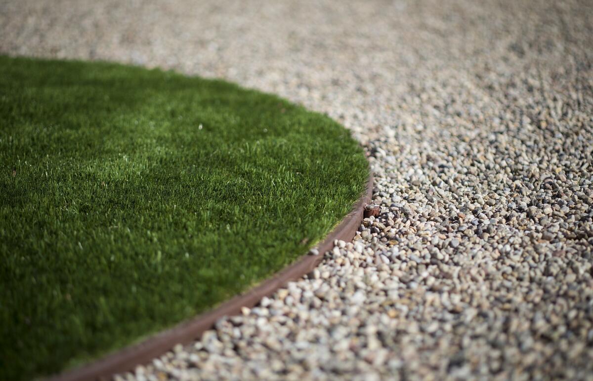 Closeup of an artificial grass circle in front of a 1930s vintage home.