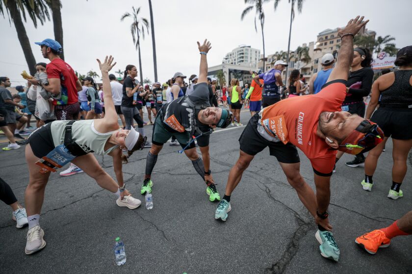 Runners stretch before the start of the Rock 'n' Roll San Diego Marathon on Sixth Avenue in San Diego on Sunday, June 4, 2023.