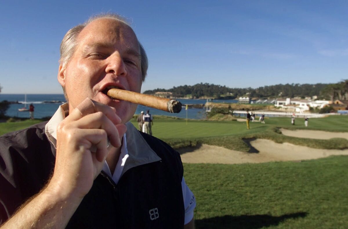 Rush Limbaugh puffs on a cigar on the Pebble Beach Golf Links in 2001.