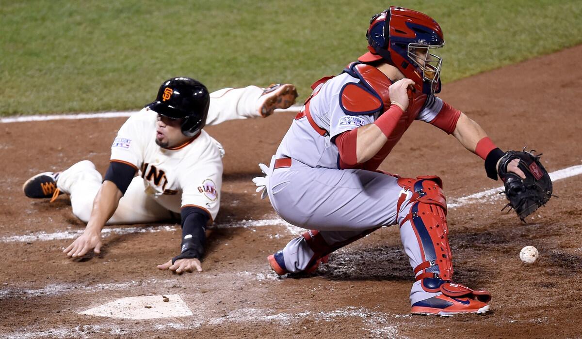 Giants left fielder Juan Perez beats the throw to Cardinals catcher Tony Cruz to score a run in the sixth inning of Game 4 in the NLCS on Wednesday night in San Francisco.