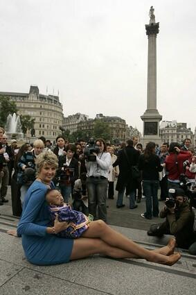 He Pingping from Inner Mongolia, the world's shortest man, sits on the lap of Svetlana Pankratova from Russia, holder of the record for woman with the longest legs, as they pose at Trafalgar Square in London, Sept. 16, 2008.