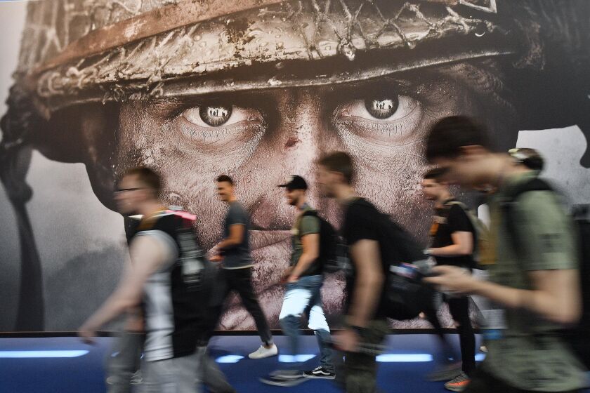 FILE - Visitors passing an advertisement for the video game 'Call of Duty' at the Gamescom fair for computer games in Cologne, Germany, Tuesday, Aug. 22, 2017. Microsoft says it struck a deal to make the hit video game Call of Duty available on Nintendo for 10 years when its $69 billion purchase of game maker Activision Blizzard goes through. The announcement Wednesday, Dec. 7, 2022 is an apparent attempt to fend off objections from rival Sony. (AP Photo/Martin Meissner, File)
