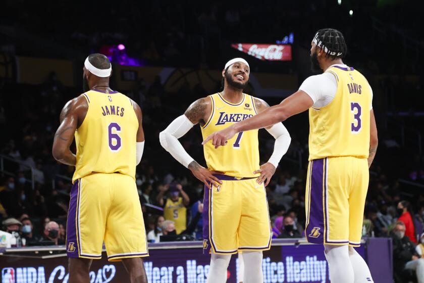 Los Angeles Lakers forwards Carmelo Anthony (7) talks with Anthony Davis (3) next to LeBron James (6) during the second half of a preseason NBA basketball game in Los Angeles, Tuesday, Oct. 12, 2021. (AP Photo/Ringo H.W. Chiu)