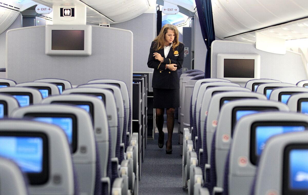 Flight attendant Tonya Johnson walks the aisles of United Airlines' 787 Dreamliner at LAX during tours of the aircraft in 2012. United has offered buyout packages of up to $100,000 primarily to veteran flight attendants.