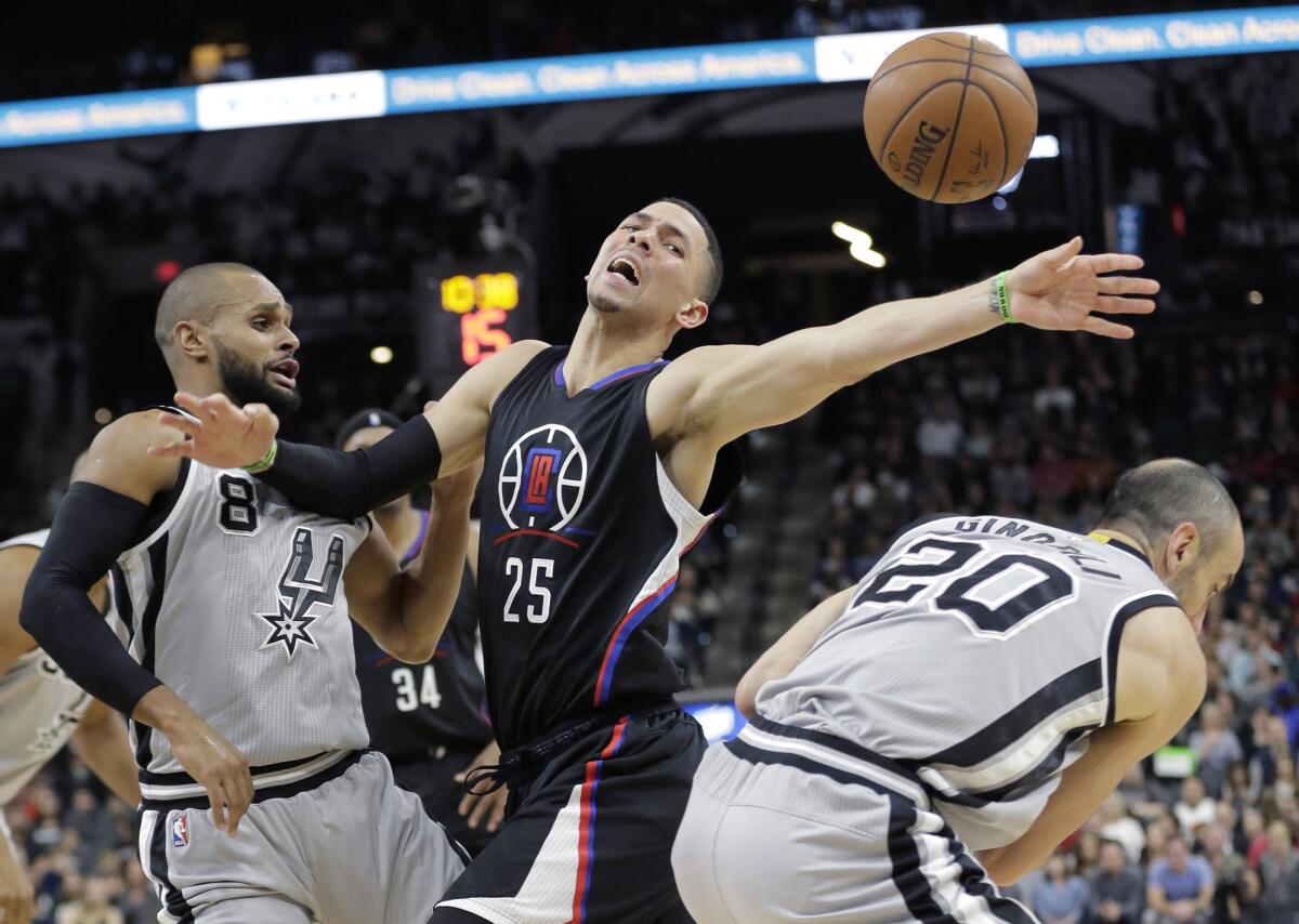 Clippers guard Austin Rivers (25) loses control of the ball as he is pressured by Spurs guards Patty Mills (8) and Manu Ginobili (20) during the first half.
