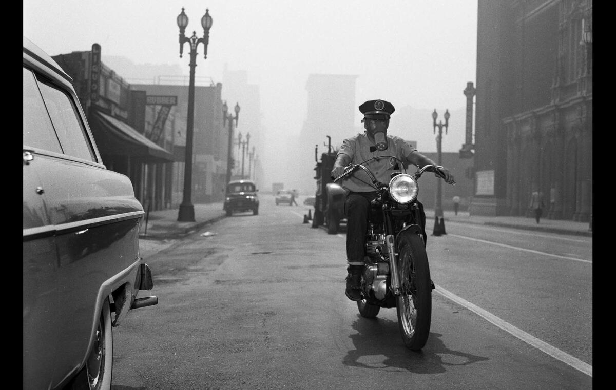 Motorcycle messenger Frank Stone uses a gas mask while making deliveries Sept. 14, 1955.