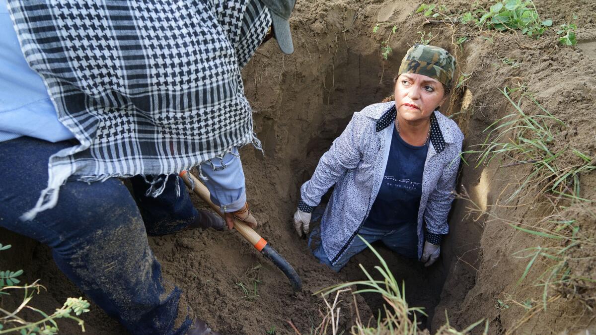 Martha Gonzalez, 58, searches inside a suspected grave in Veracruz, Mexico. Her son, a municipal policeman, disappeared in 2013.