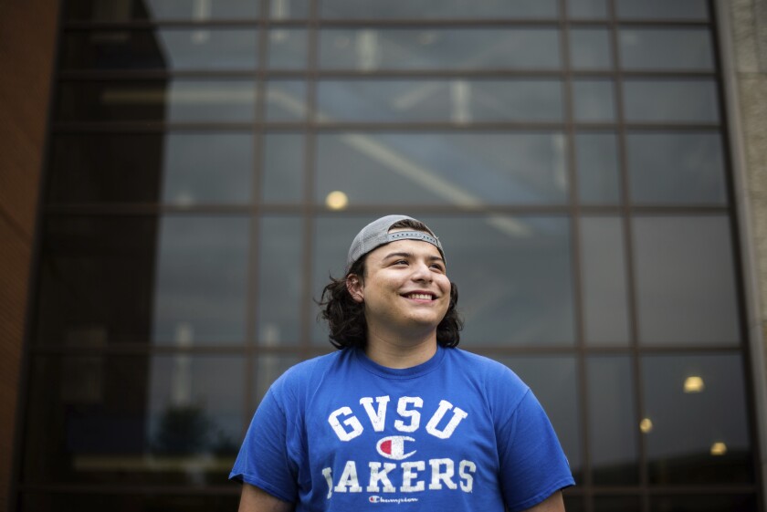 In this image provided by Grand Valley State University, Jordan Bernal, a Sport Management student at Grand Valley State University, poses outside Kindschi Hall of Science in Allendale, Mich. on Sept. 1, 2020. Bernal said first-generation college students like himself often struggle to find and take advantage of resources and scholarships once they enroll. (Kendra Stanley-Mills/ Grand Valley State University via AP)