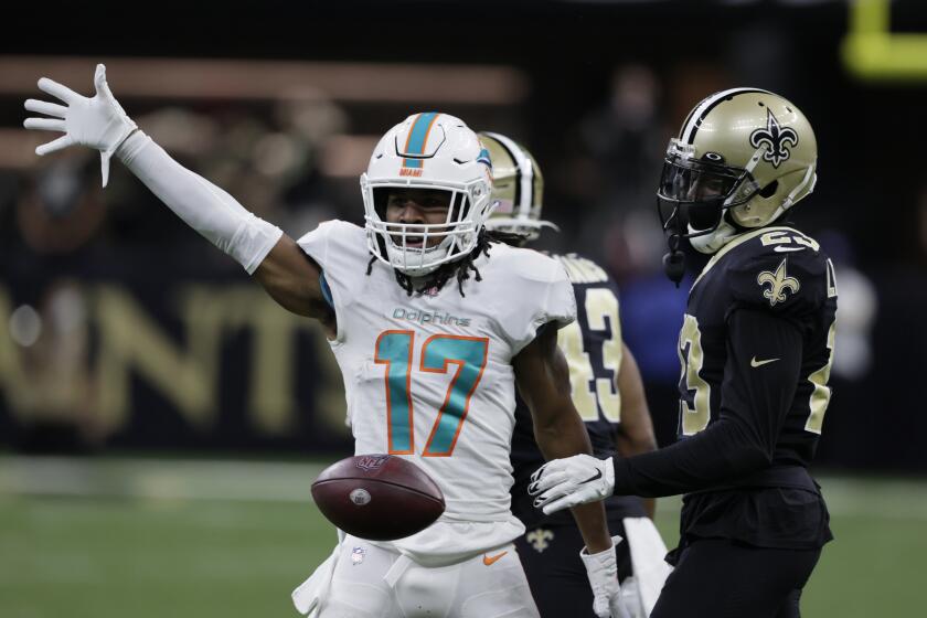Miami Dolphins wide receiver Jaylen Waddle (17) drops the ball in front of New Orleans Saints cornerback Marshon Lattimore (23) after making a catch during the first half of an NFL football game Monday, Dec. 27, 2021, in New Orleans. (AP Photo/Butch Dill)