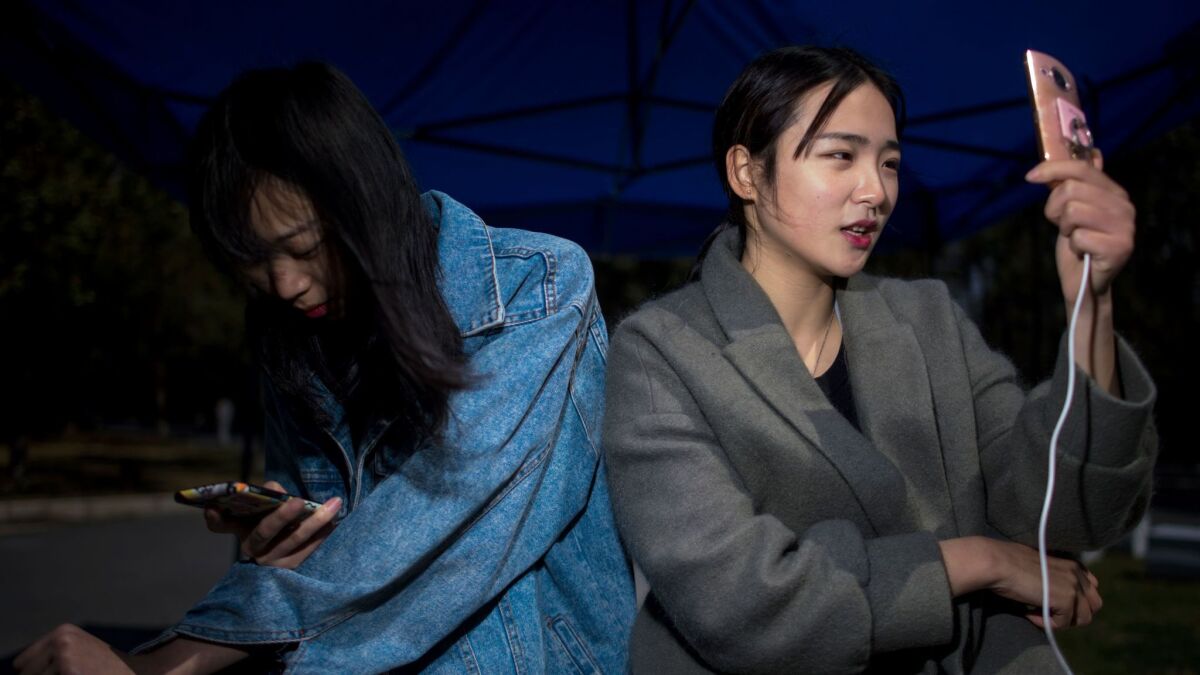 Jiang Mengna, right, broadcasts a live stream to viewers from Yiwu Industrial and Commercial College in Zhejiang province. Millions of Chinese millennials are speaking directly to the country's 700 million smartphone users, streaming their lives to lucrative effect.