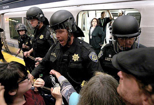 Bay Area Rapid Transit police push back demonstrators who are trying to keep a train from leaving the Civic Center station in San Francisco. See full story