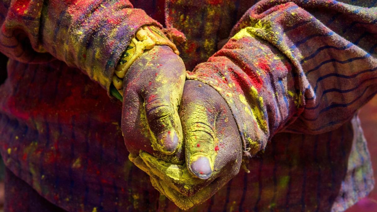 A young Indian child holds yellow colour in his hands during the Holi Festival in Jaisalmer.
