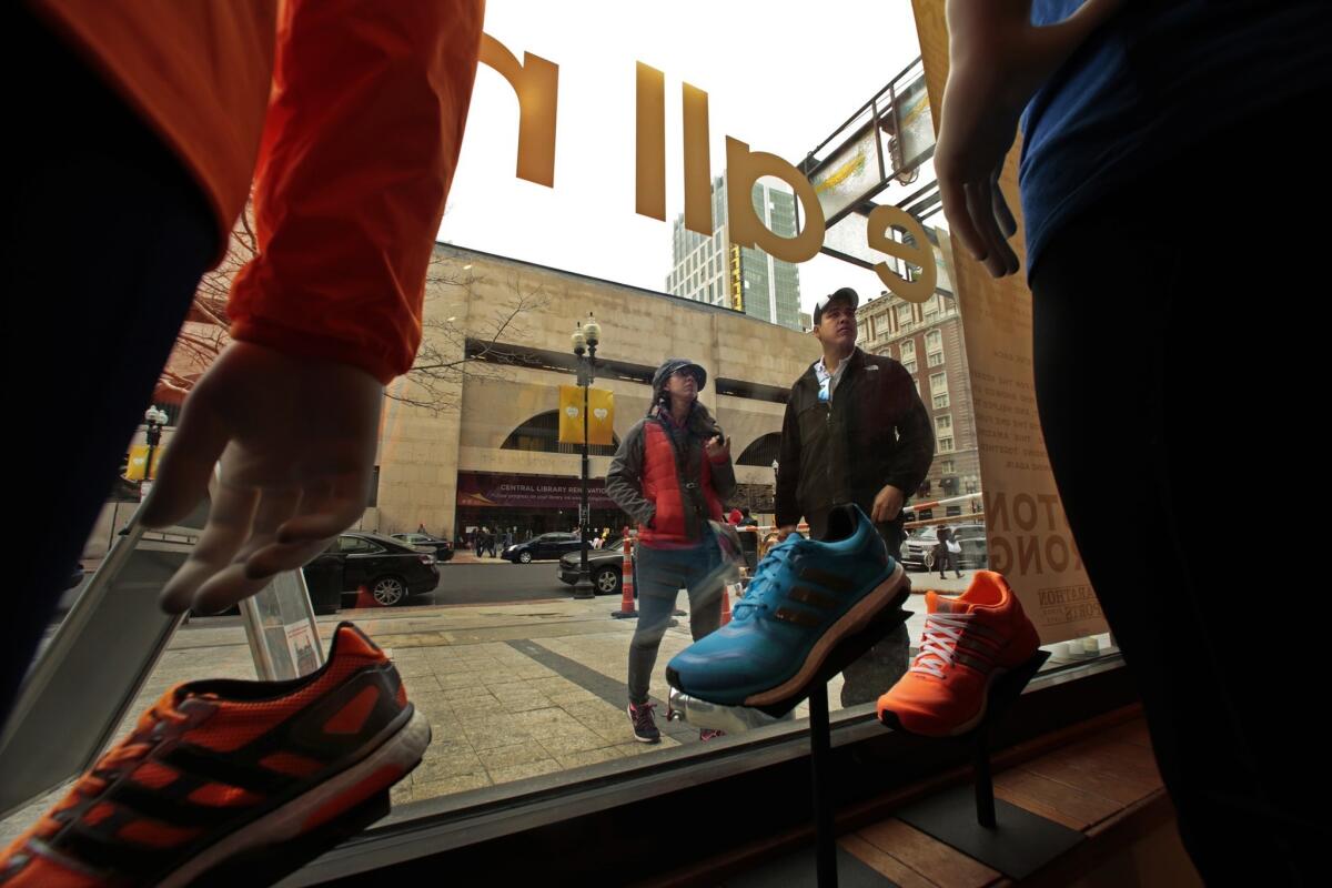 Running shoes and clothes fill the display window at Marathon Sports, steps from where the first bomb exploded. A poster facing the sidewalk thanks all the people who helped get the store back up and running after the bombing.