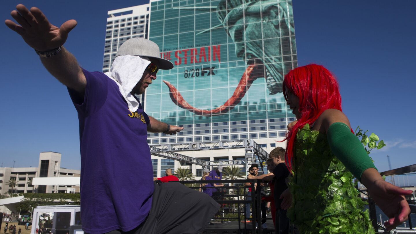 Chris Toupence, left, shows Faith Holman the proper technique for jumping onto an inflatable during the first day of Comic-Con 2016.