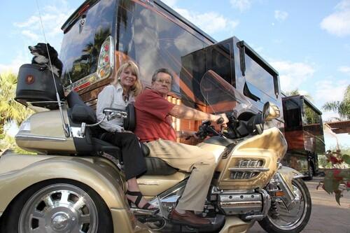 Glenn Patch and his wife, Susie, on their Honda Gold Wing three-wheeler, in front of their 47-foot Prevost motor coach at a luxury RV resort in Palm Springs. Patch, a real estate entrepreneur and car collector, has decided to sell his collection of 1957 cars and close the '57 Heaven Museum in Branson, Mo.