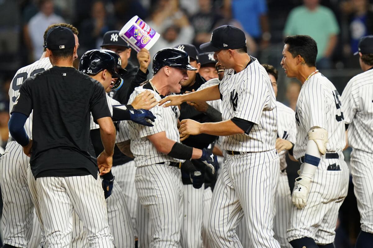 New York Yankees' Josh Donaldson, center, celebrates with teammates after hitting a walk-off grand slam during the tenth inning of a baseball game against the Tampa Bay Rays Wednesday, Aug. 17, 2022, in New York. The Yankees won 8-7. (AP Photo/Frank Franklin II)