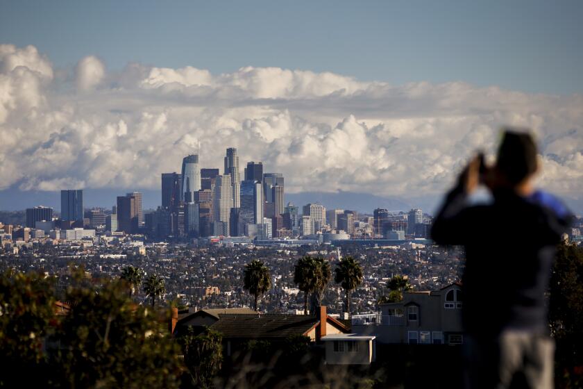 LOS ANGELES,CA --SATURDAY, DECEMBER 24, 2016--After dropping a friend at LAX airport, Mike Che, from West Hollywood, stopped at Kenneth Hahn Recreation Area to take in the skyline of downtown Los Angeles, CA, following a winter storm, Christmas Eve morning, Dec. 24, 2016. (Jay L. Clendenin / Los Angeles Times)