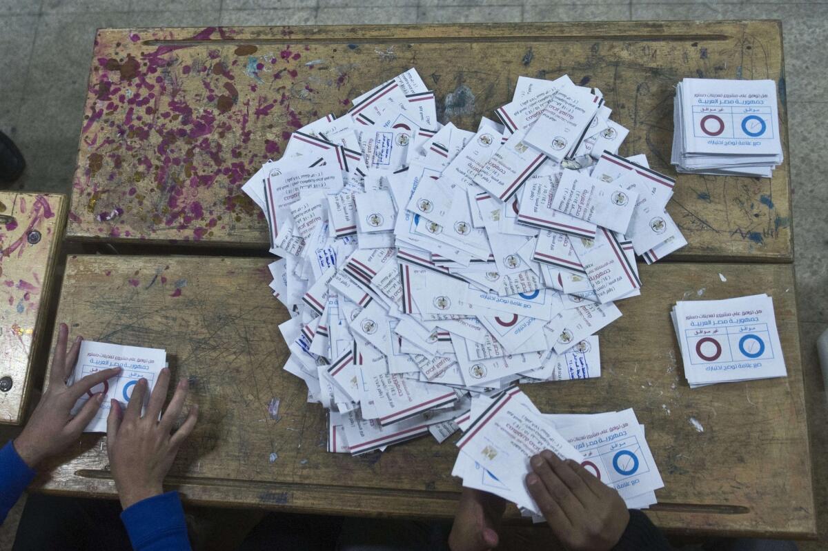Egyptian polling station officials count ballots in Cairo on Thursday at the end of the second day of voting in a referendum on a new constitution.