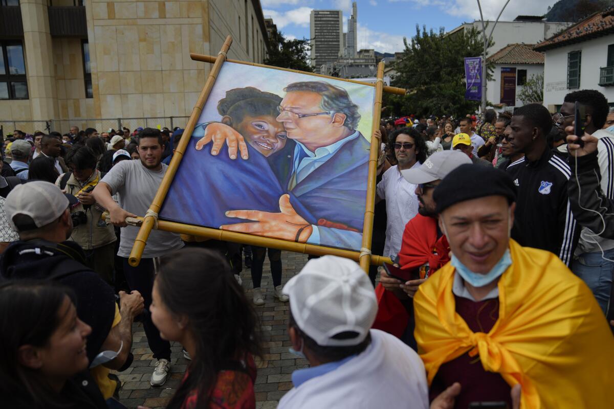 Supporters of new President Gustavo Petro display a painting of him with new Vice President Francia Marquez.