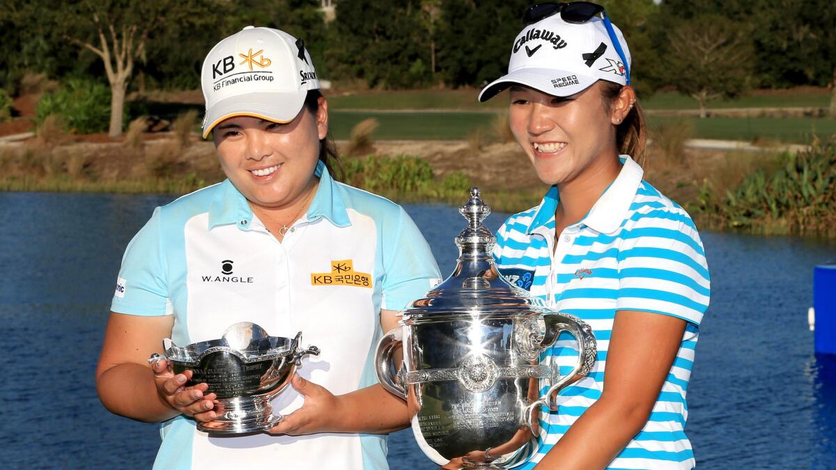Inbee Park, left, and Lydia Ko pose with their hardware at the LPGA Tour's season-ending CME Group Tour Championship on Sunday.