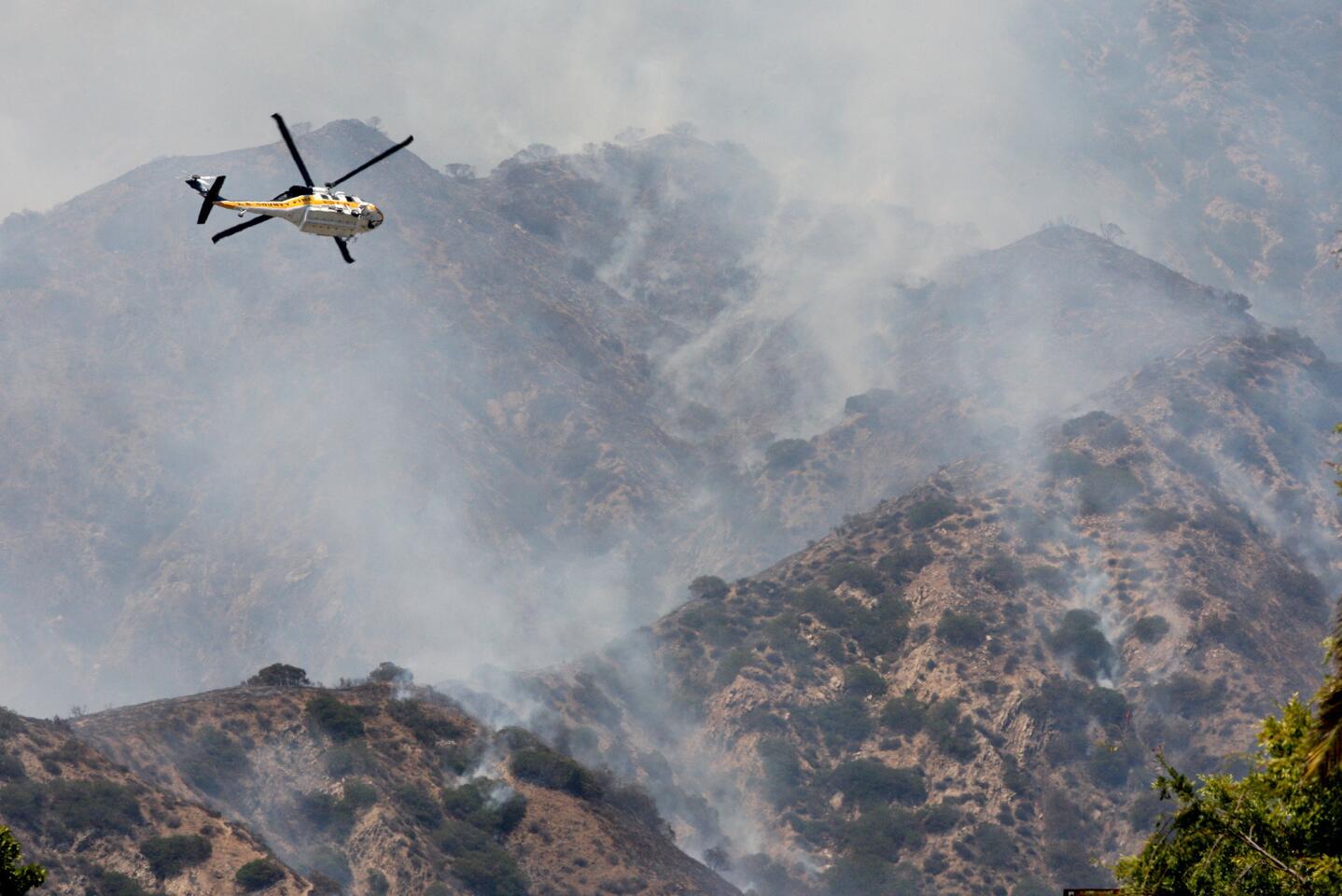 An L.A. County helicopter makes a pass over a brushfire behind Brand Park on Sunday, June 22, 2014.