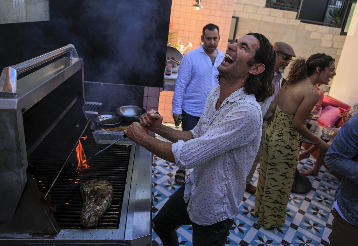 Diego Caivano entertains guests as he grills.