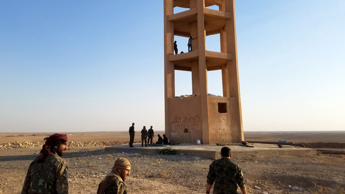 U.S.-backed Syrian opposition fighters standing watch against Islamic State atop a water tower in northeastern Syria.