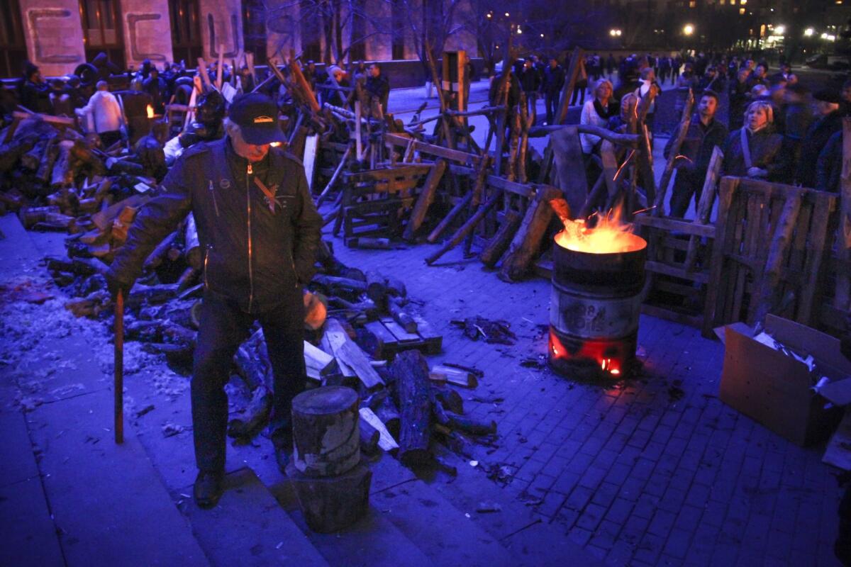People gather near a barricade set up by protesters at the regional administration building in Donetsk, Ukraine.