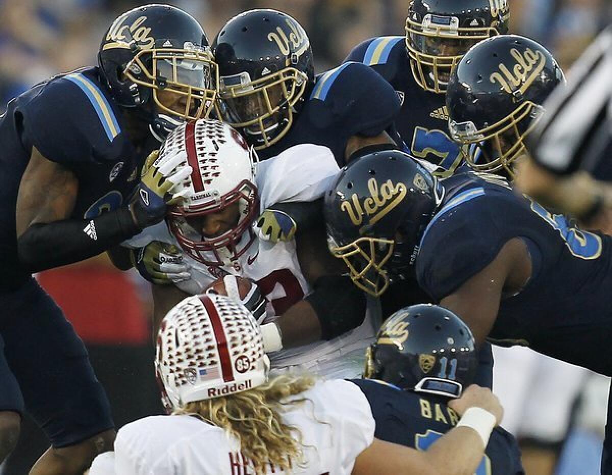 Stanford running back Stepfan Taylor is swarmed by the UCLA defense during Saturday's game.